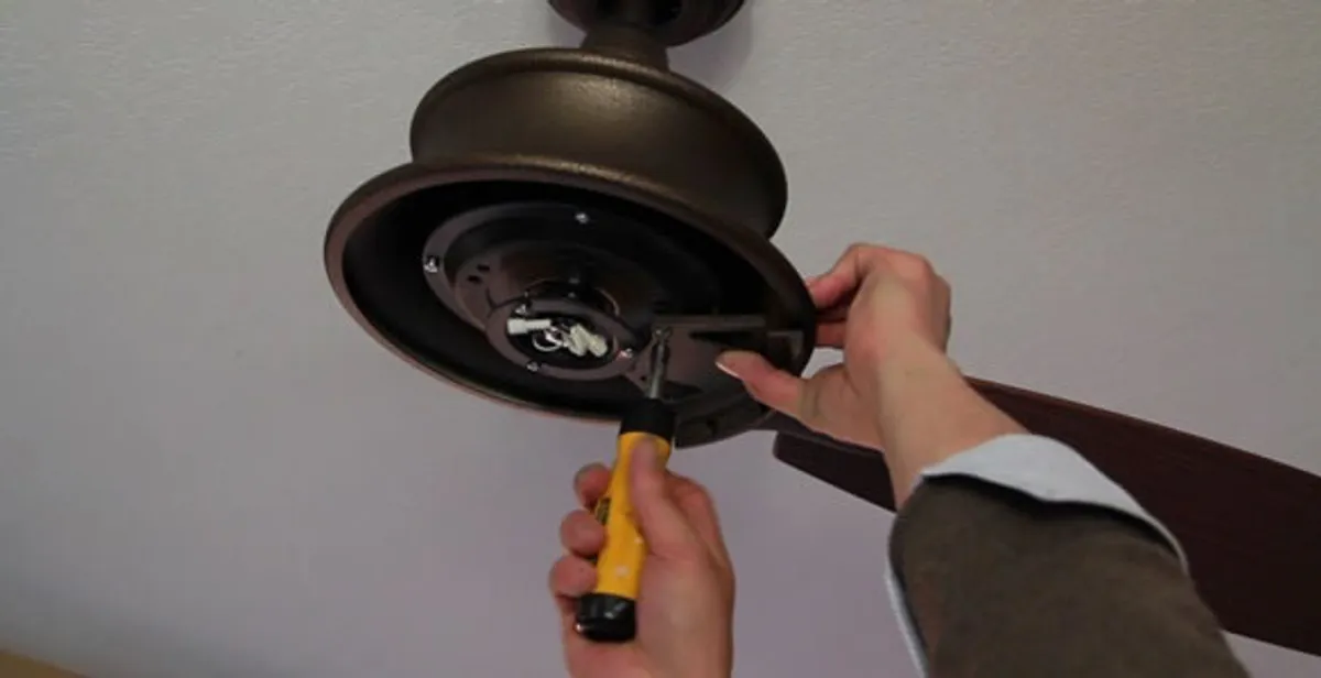 Electrician installing ceiling fan mounting bracket and fixture in Fort Lauderdale, FL