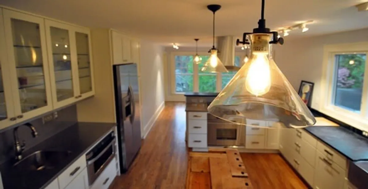 Residential electrician installing modern indoor light fixture in a home in Fort Lauderdale, FL